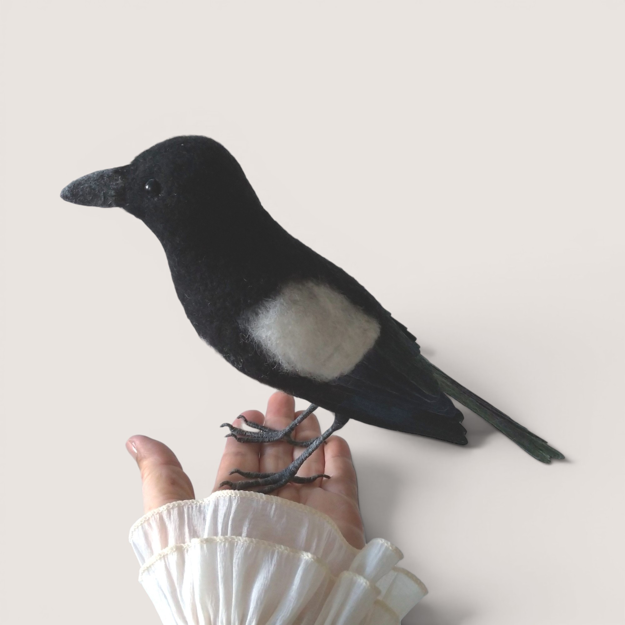 Magpie 4 Needle felted magpie sculpture shown in hand for scale
