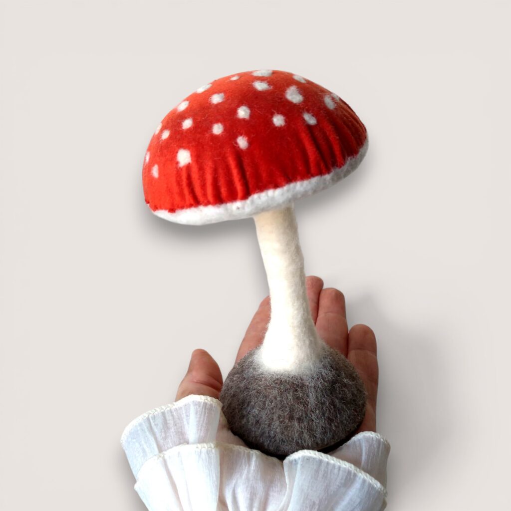 Velvet-capped mushroom sculpture in Rowan Berry velvet by Grey Wren Studio, shown in hand for scale.